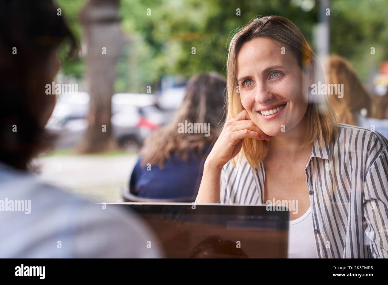 Mid-shot of two female co-workers having a good time while working in outdoors office Stock Photo