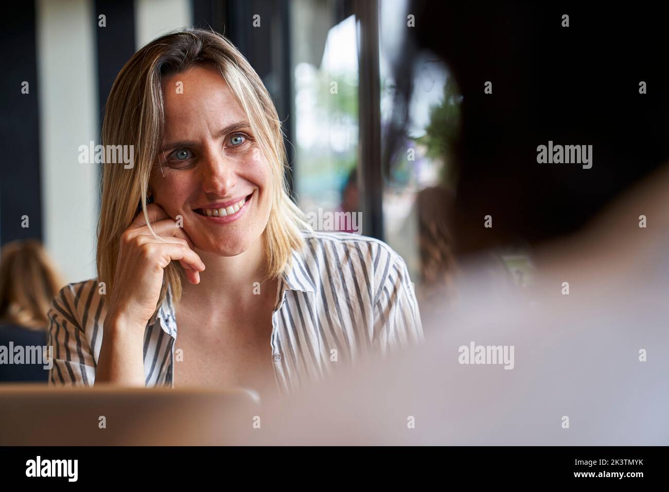 Medium front shot of attractive business woman and of colleague's back at company's cafeteria Stock Photo