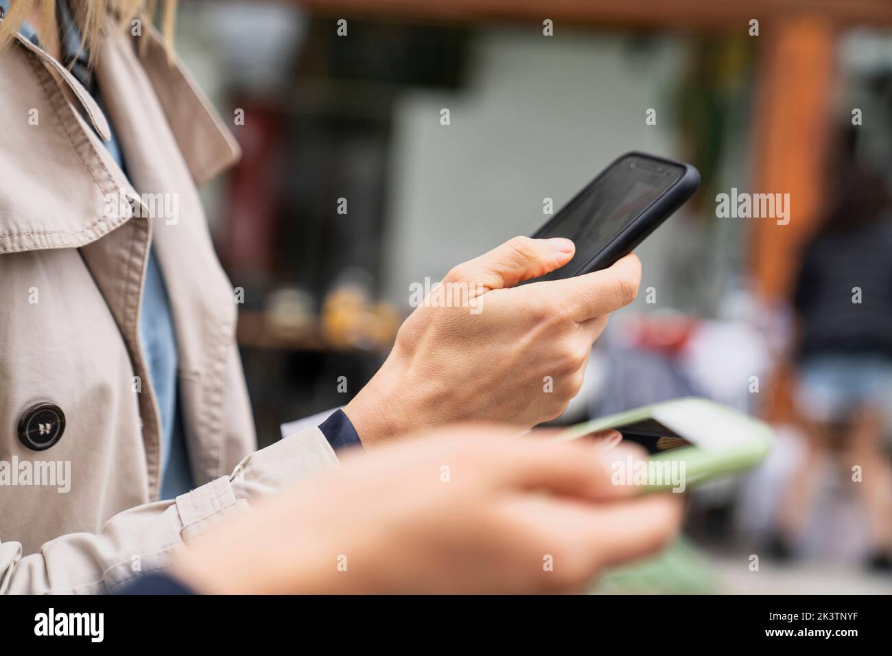 Close-up photo of hands holding smartphones while working outdoors Stock Photo