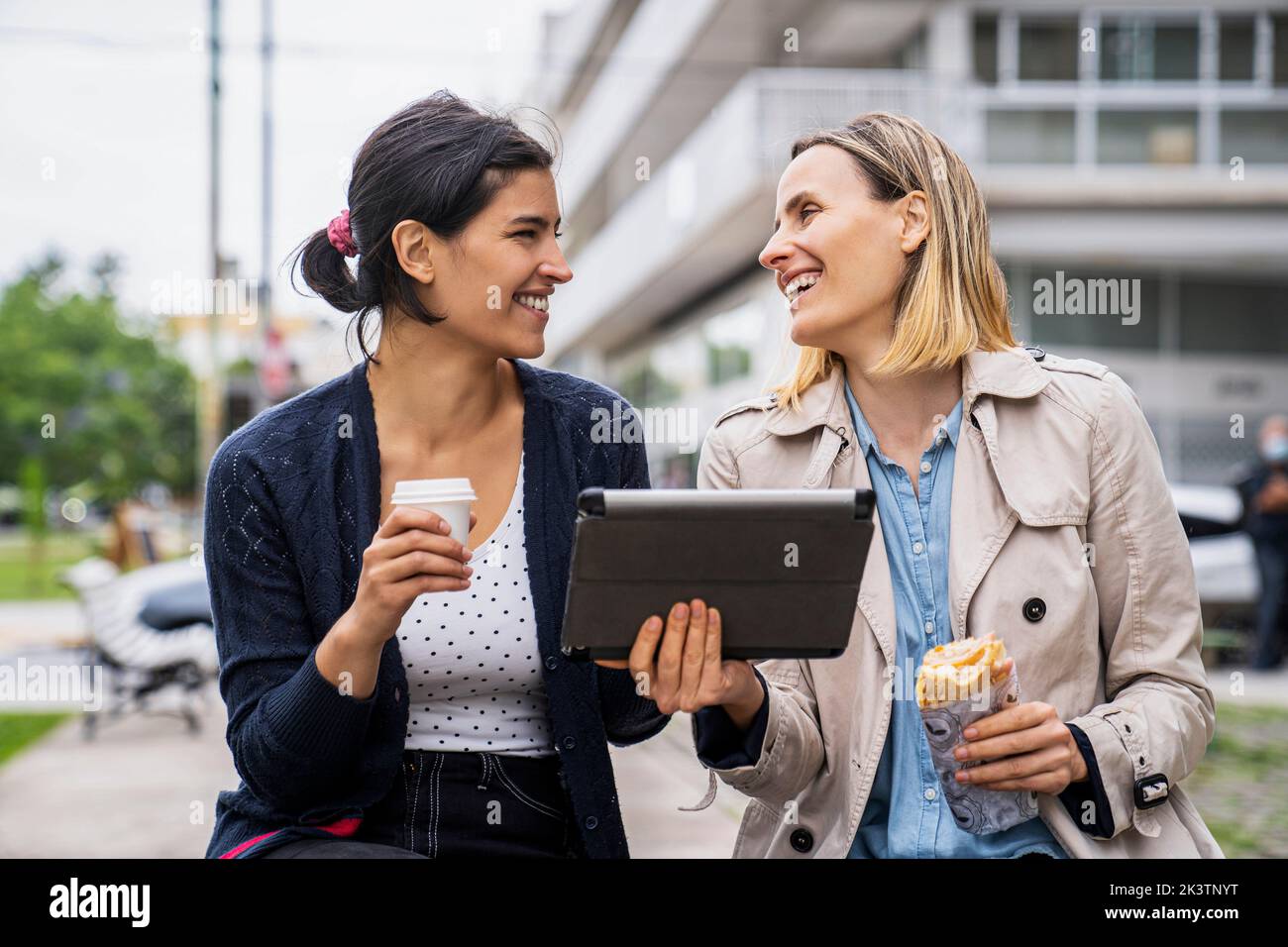 Front view shot of two female digital nomads working outdoors and having a good time Stock Photo