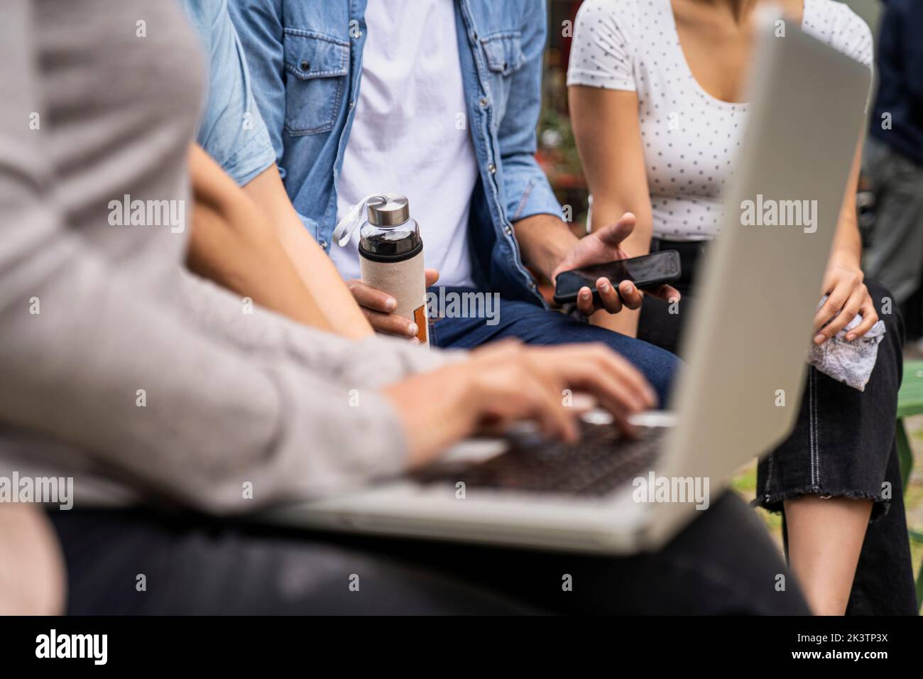 Close-up shot of several people's hands holding smartphones and laptop computer Stock Photo