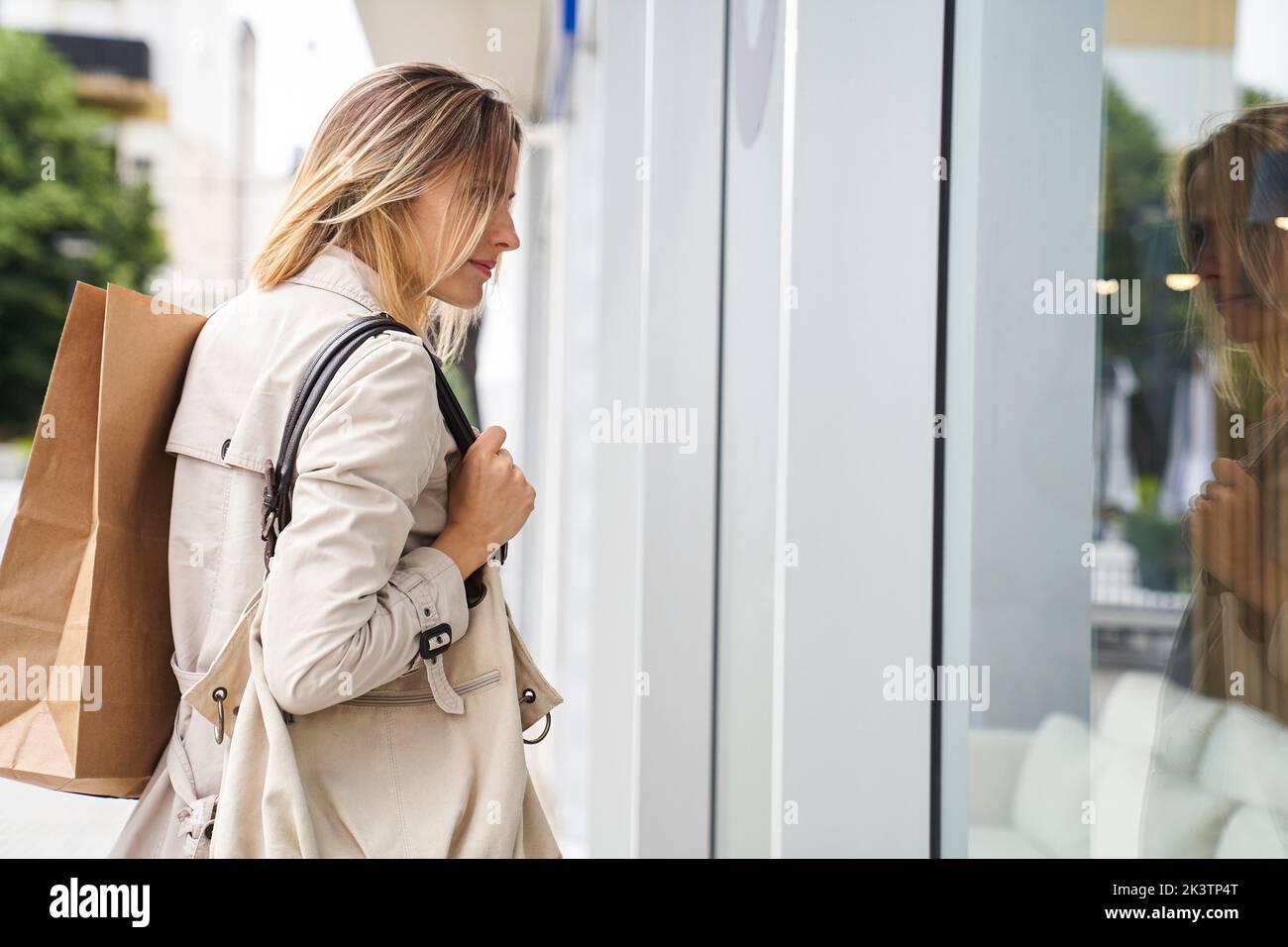Side view shot of woman carrying bags while window shopping Stock Photo