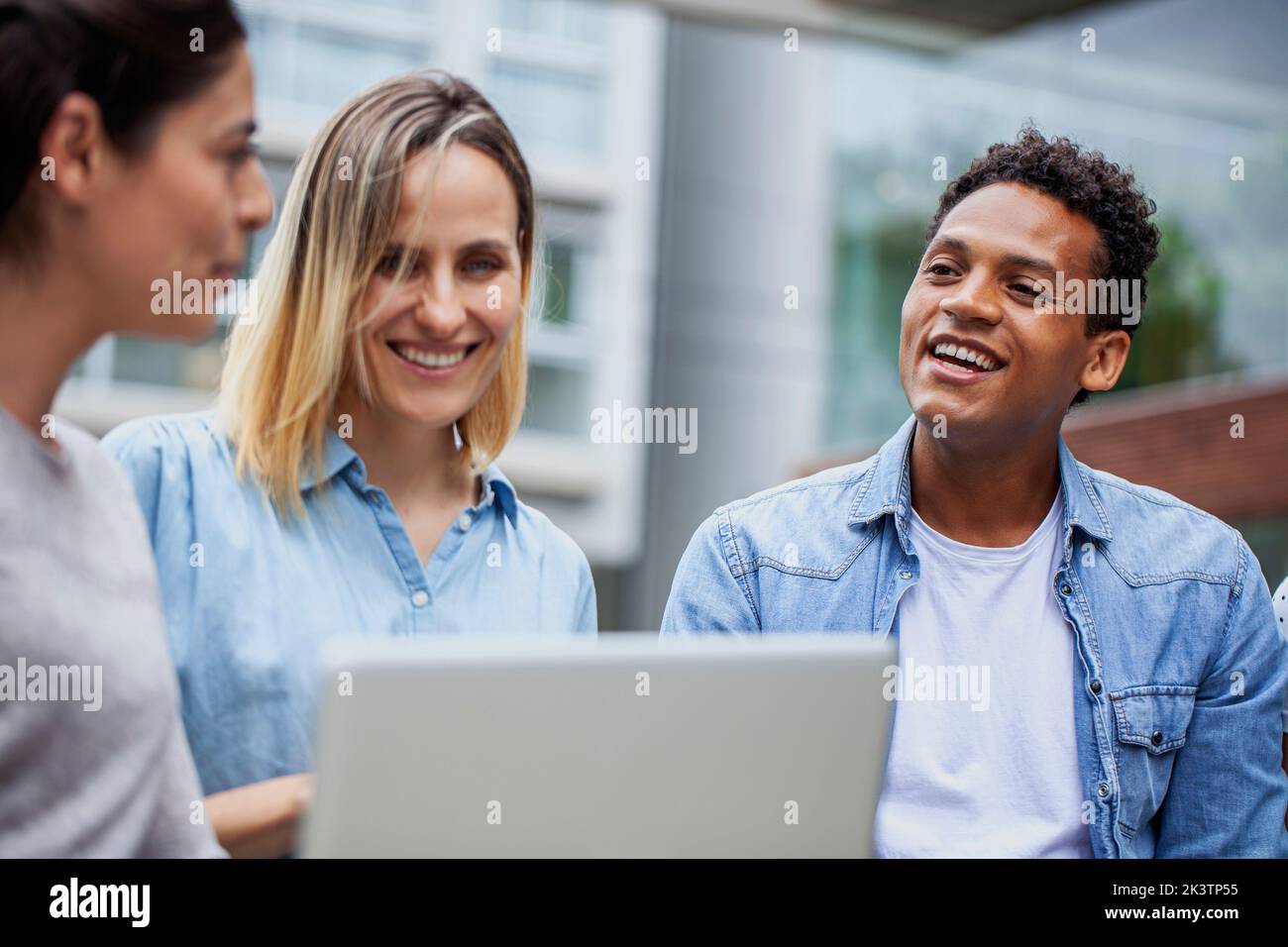 Coworkers sitting outdoors during informal meeting Stock Photo
