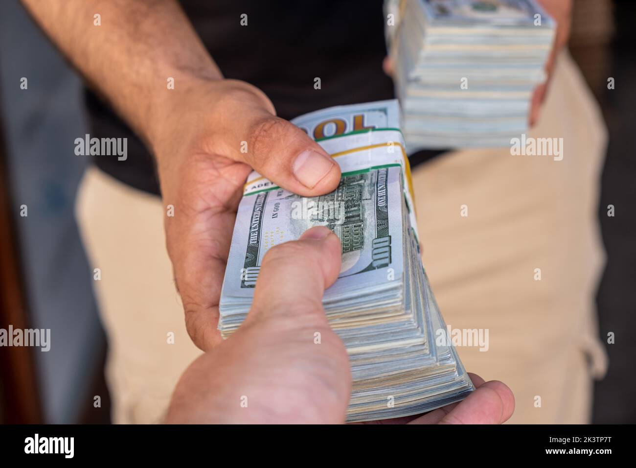 Bundles of US dollars in the hands of businessman. Selective focus Stock Photo