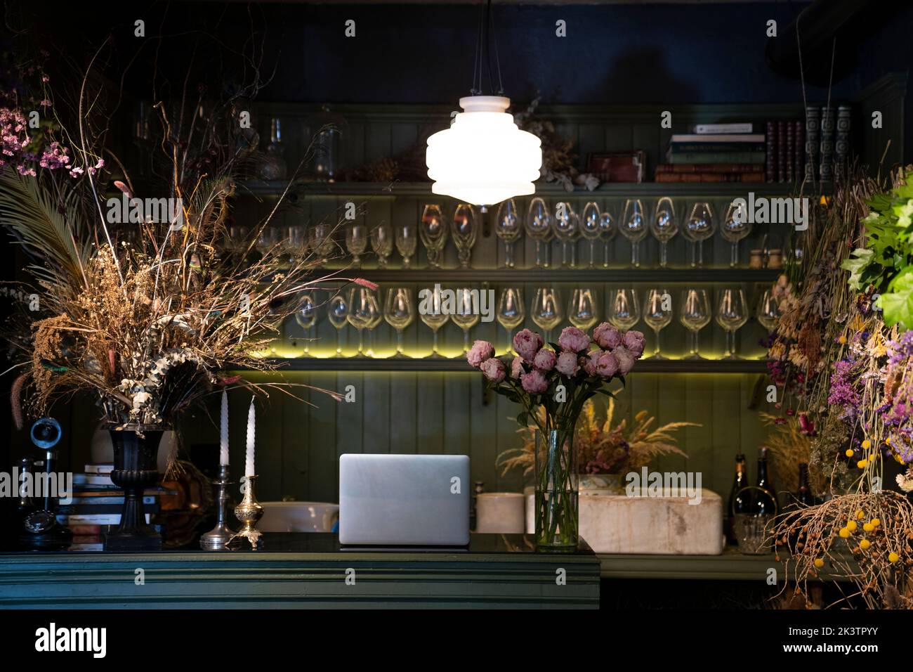 Low key shot of a wine bar decorated with variety of dried flowers bouquets and vases Stock Photo
