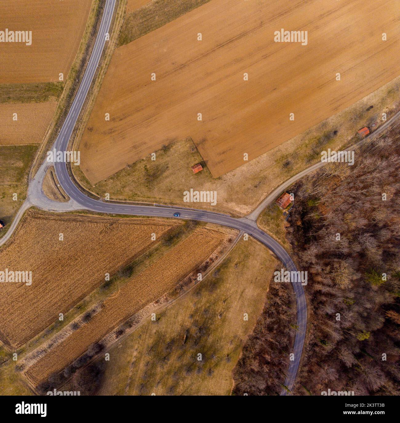 Aerial top view of road crossing the fields Stock Photo