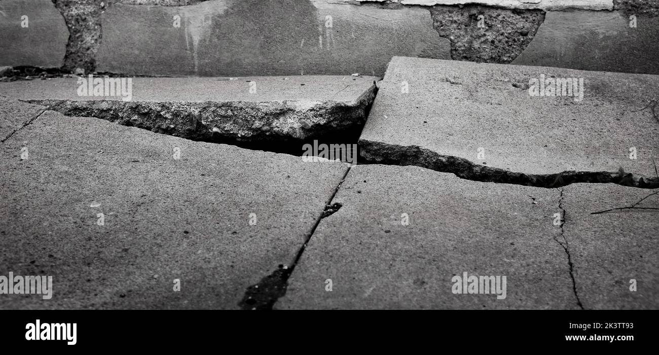 Brokent cement sidewalk with big cracks dangerous for walking Stock Photo