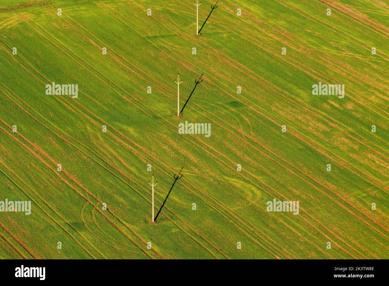 Power mast for high voltage electricity with cables in field. Aerial photo Stock Photo