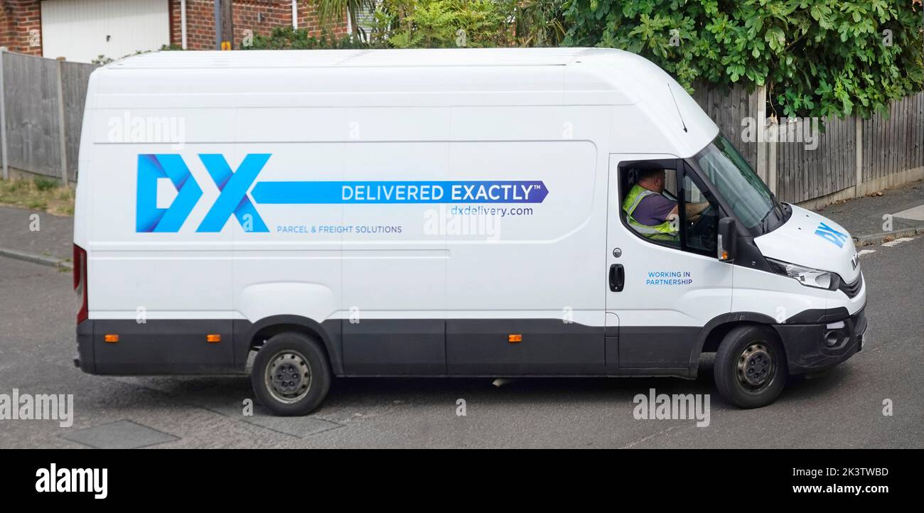 White panel commercial vehicle operated by DX delivery van British mail courier & logistics business company making residential deliveries England UK Stock Photo