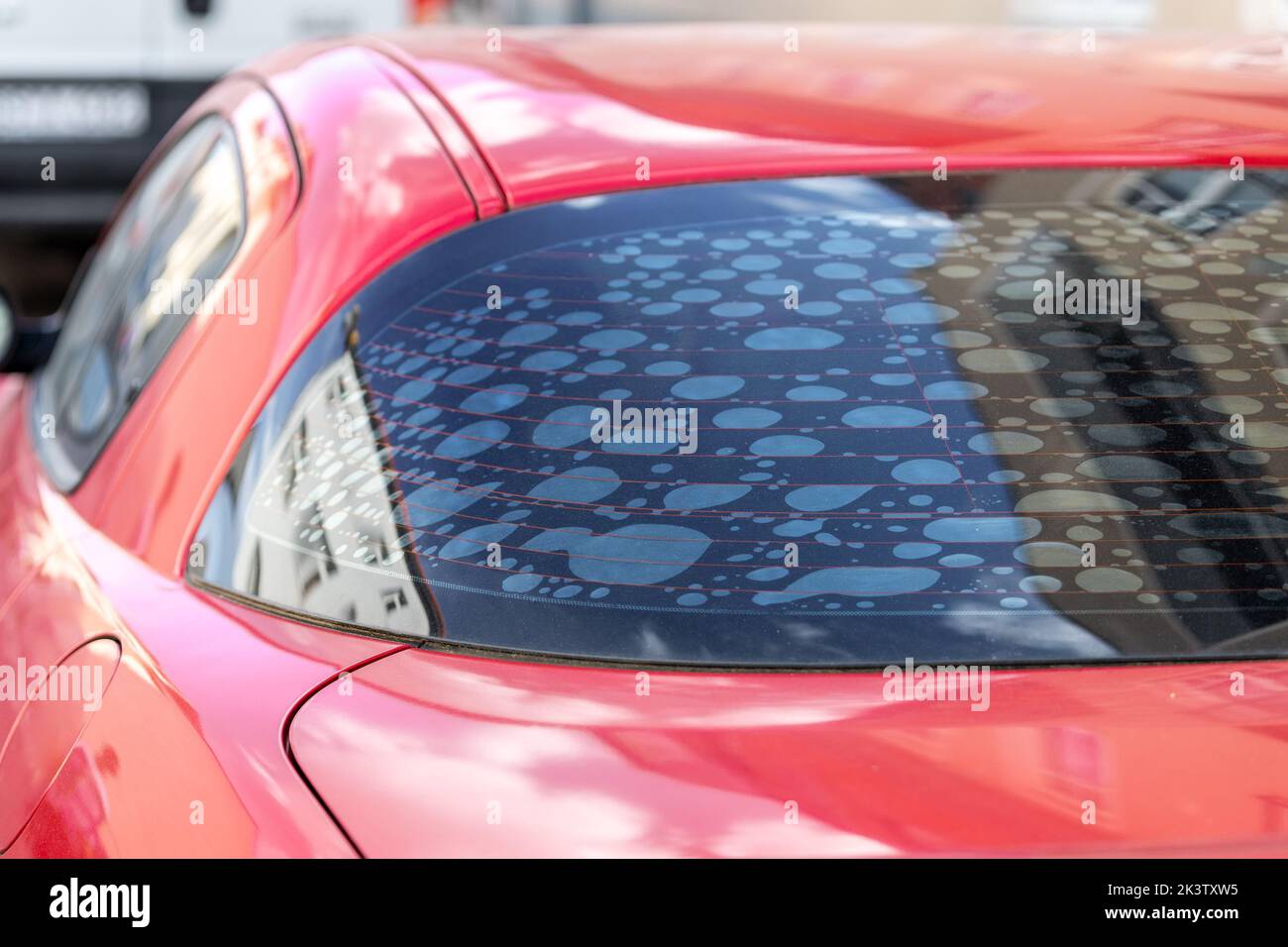 Rear car window with old adhesive defective dark sunproof tint film in