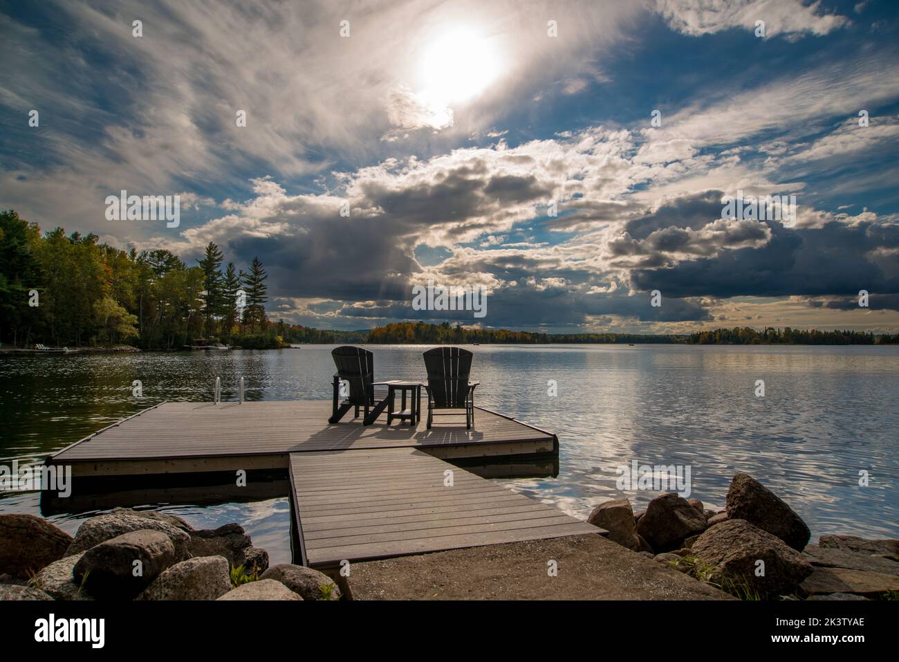 Adirondack chairs on a dock facing White Lake, Ontario, Canada Stock Photo