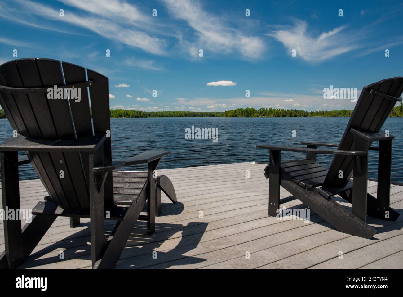 Adirondack chairs on a dock facing White Lake, Ontario, Canada Stock Photo