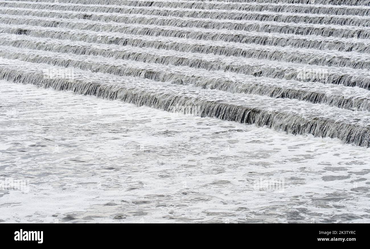 River Trent water flowing over steps in Beeston Rylands Weir creating bubbles and foam downstream Stock Photo