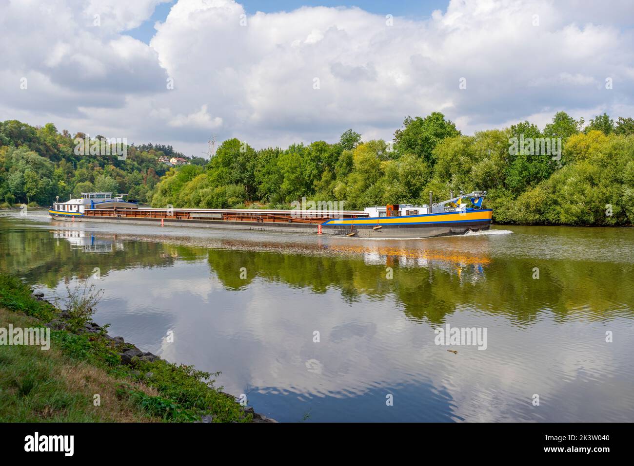 Cargo ship on a river at summer time in sunny ambiance Stock Photo