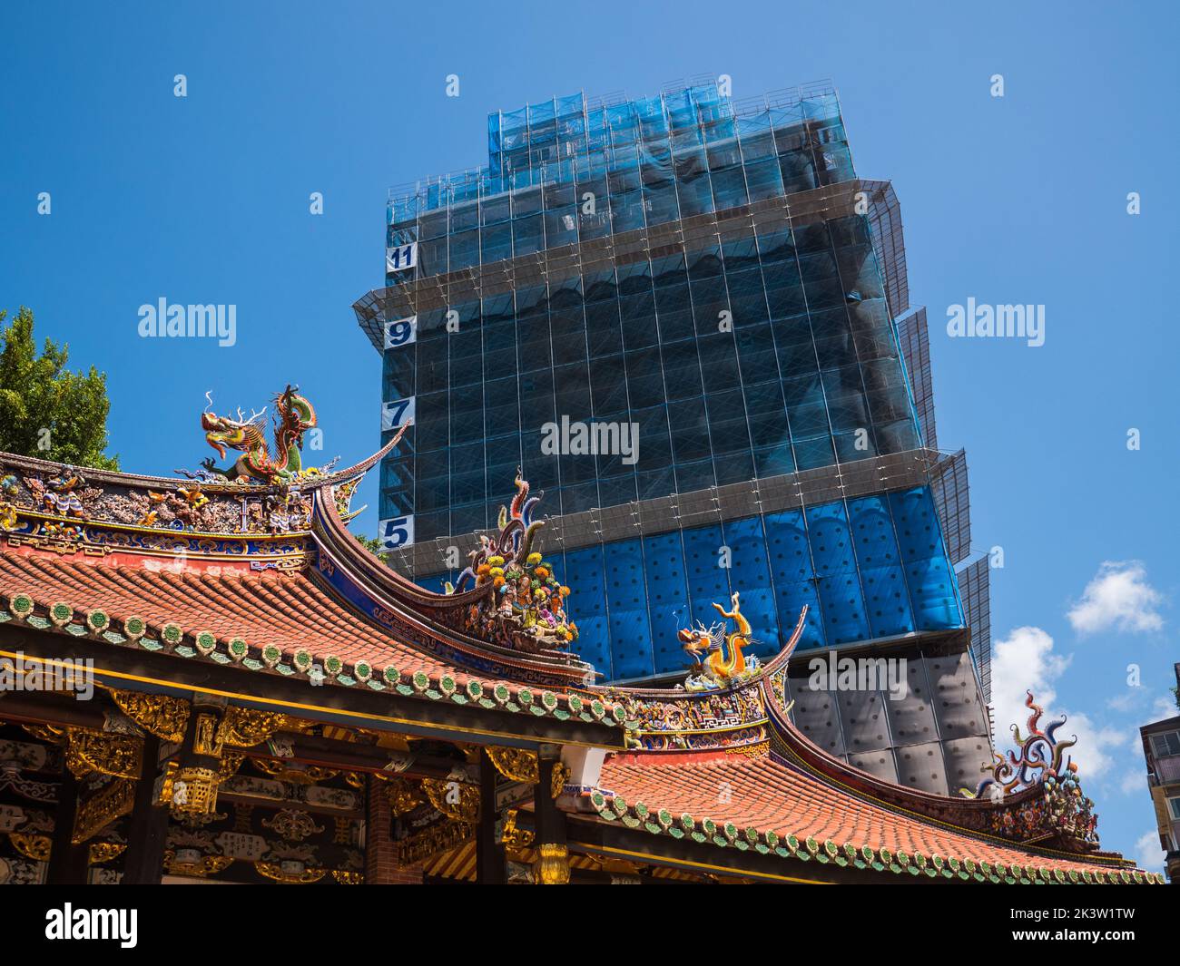 Ornate temple roof with modern urban construction, Taipei Stock Photo