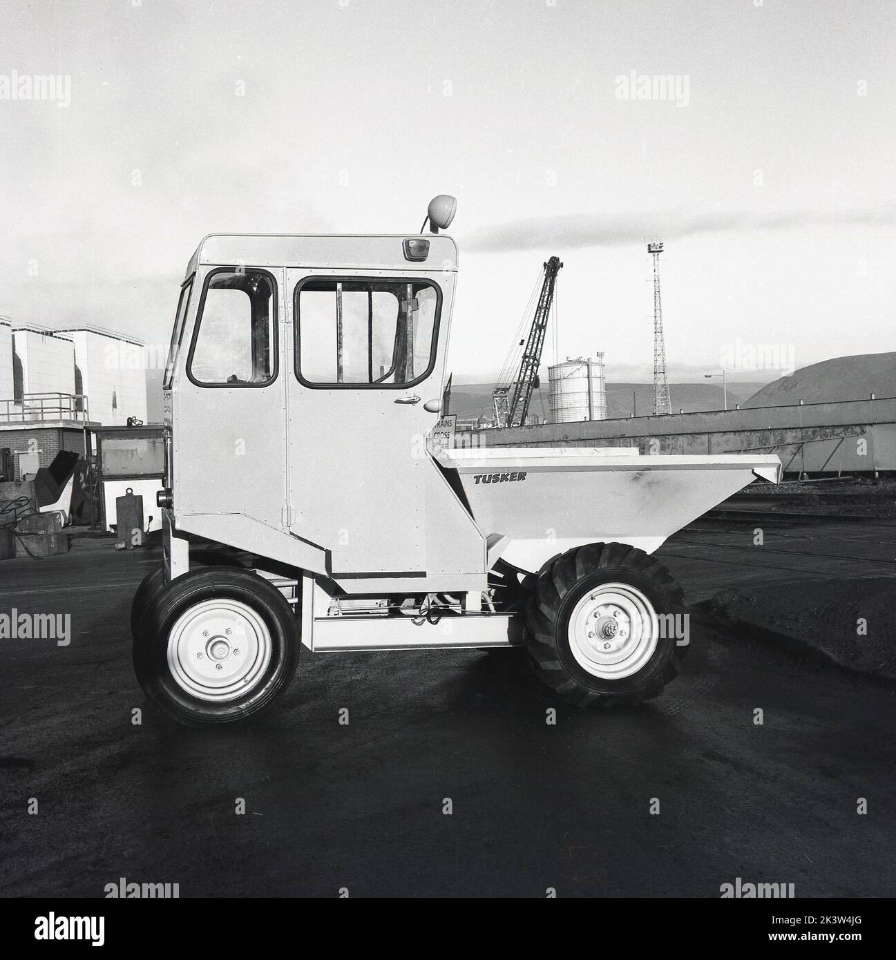 1950s, historical, side view of a mini back or reverse dumper truck, with cabin, on site at the Steelworks at Abbey Works, Port Talbot, Wales, UK. The British company Thwaites designed and manufactured the very first site dumper,  a 15 cwt-capacity, two-wheel drive, reverse tip machine. Stock Photo