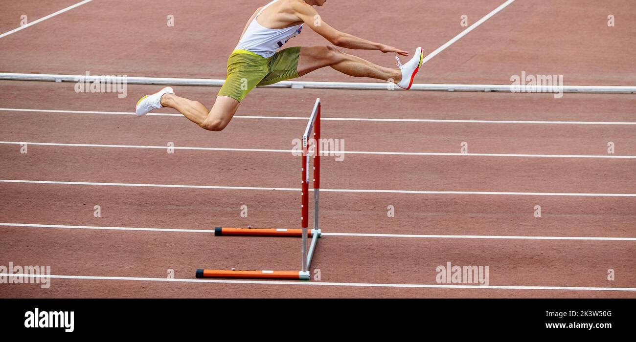 male athlete running 400 meters hurdles at stadium Stock Photo Alamy