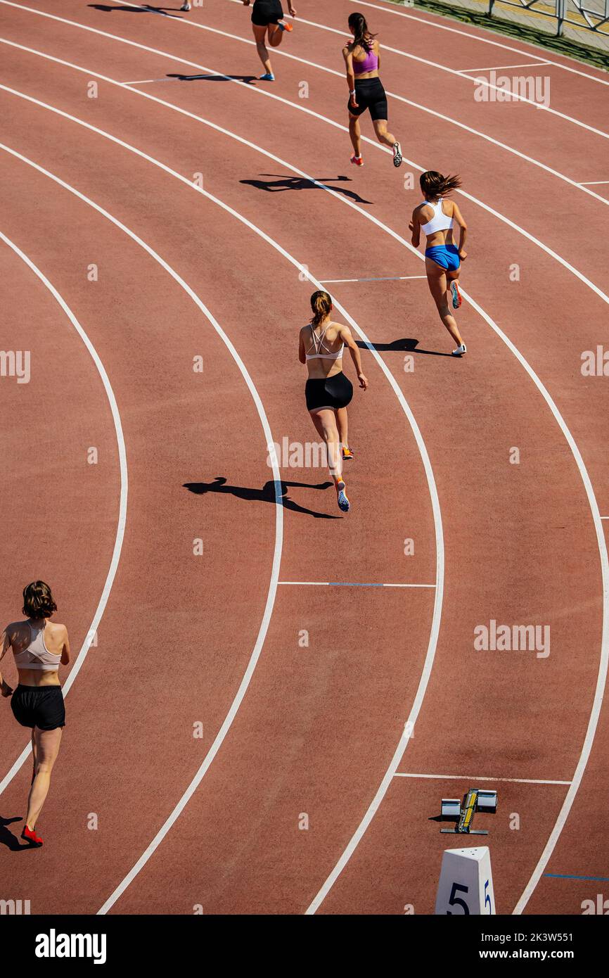 group female athletes start running 400 meters Stock Photo