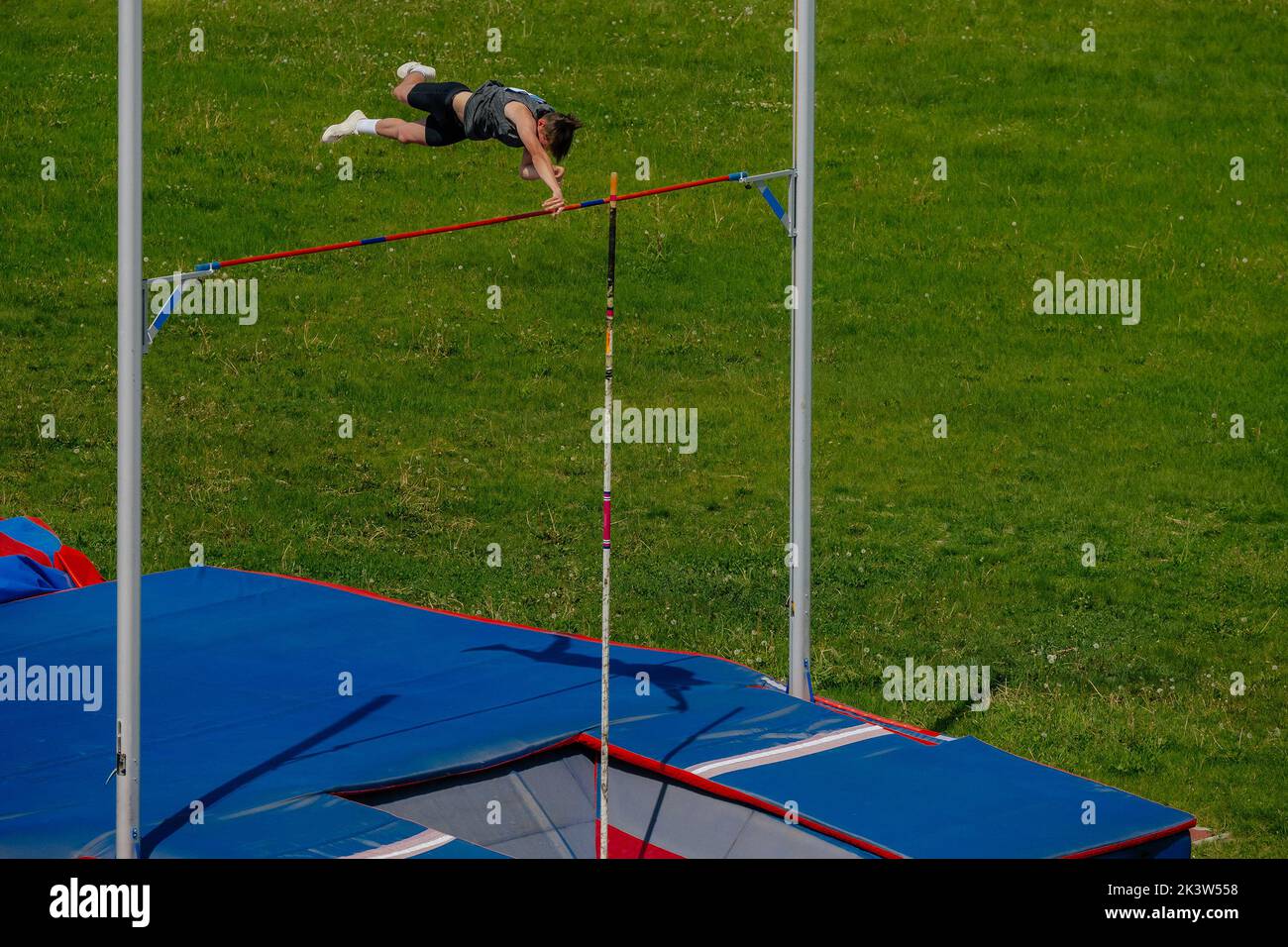 male athlete pole vault on background of green field Stock Photo