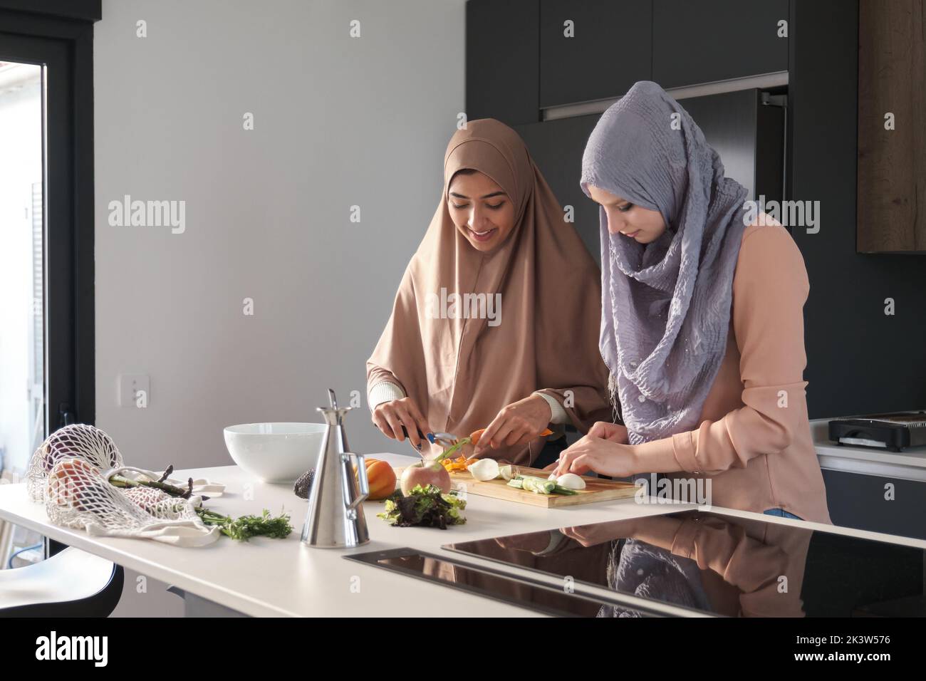 Two Muslim Women Slicing Chopping And Peeling Vegetables At Kitchen two-muslim-women-slicing-chopping-and-peeling-vegetables-at-kitchen
