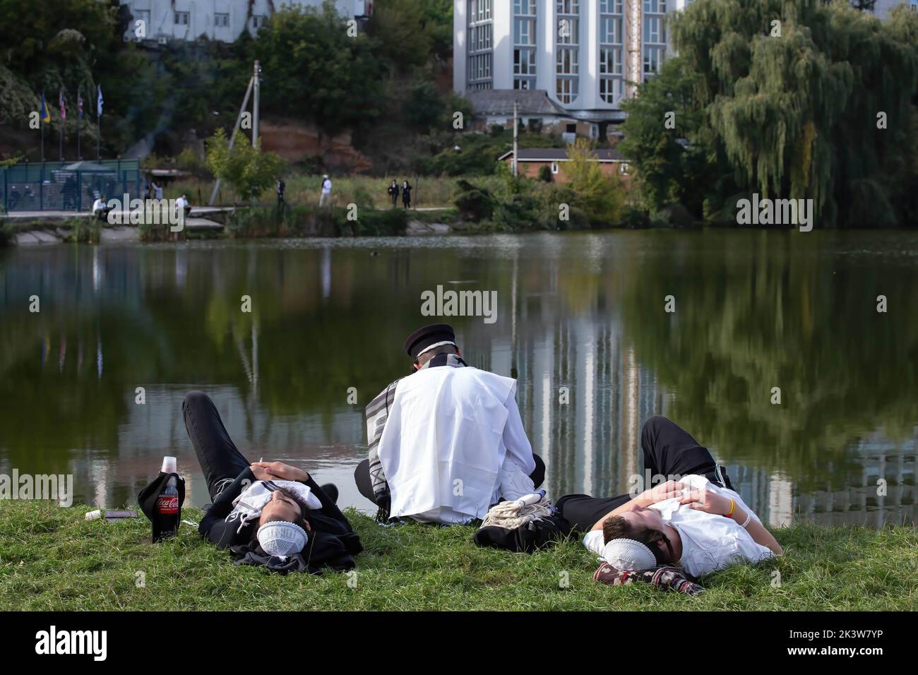 Ultra-Orthodox Jewish pilgrims seen resting next to the river of Umanka near the tomb of Rabbi Nachman during the celebration. Every year, thousands of Orthodox Bratslav Hasidic Jews from different countries gather in Uman to mark Rosh Hashanah, Jewish New Year, near the tomb of Rabbi Nachman, a great-grandson of the founder of Hasidism. Stock Photo