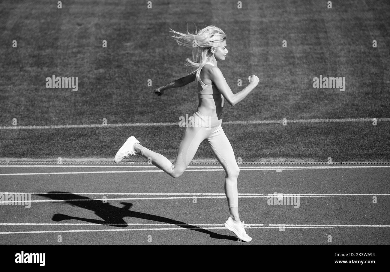 athletic woman in fitness wear running on stadium, marathon Stock Photo