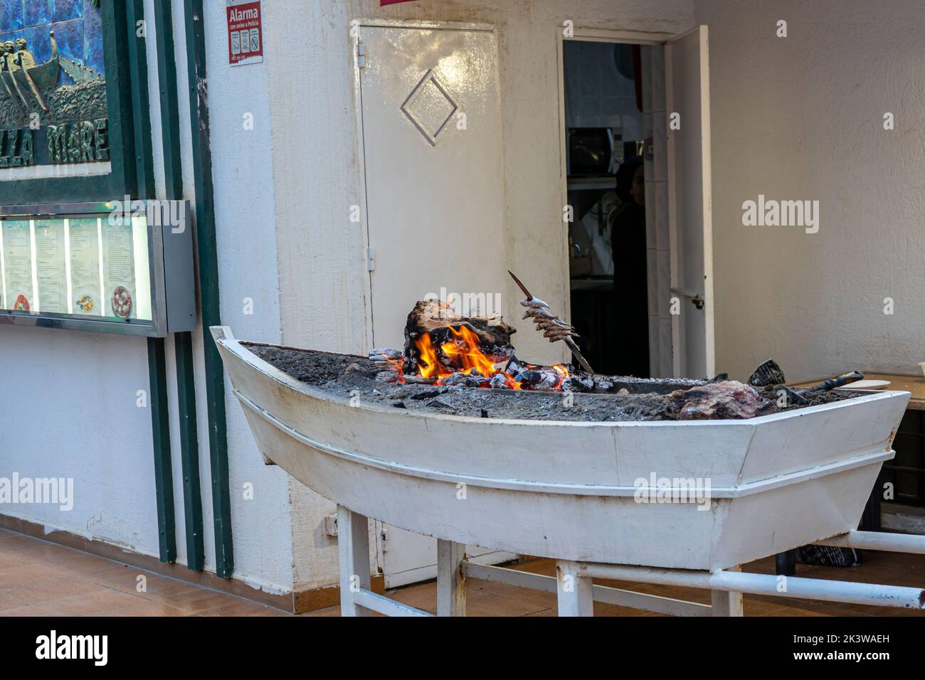 Cooking sardines fish on BBQ using traditional boat Stock Photo Alamy
