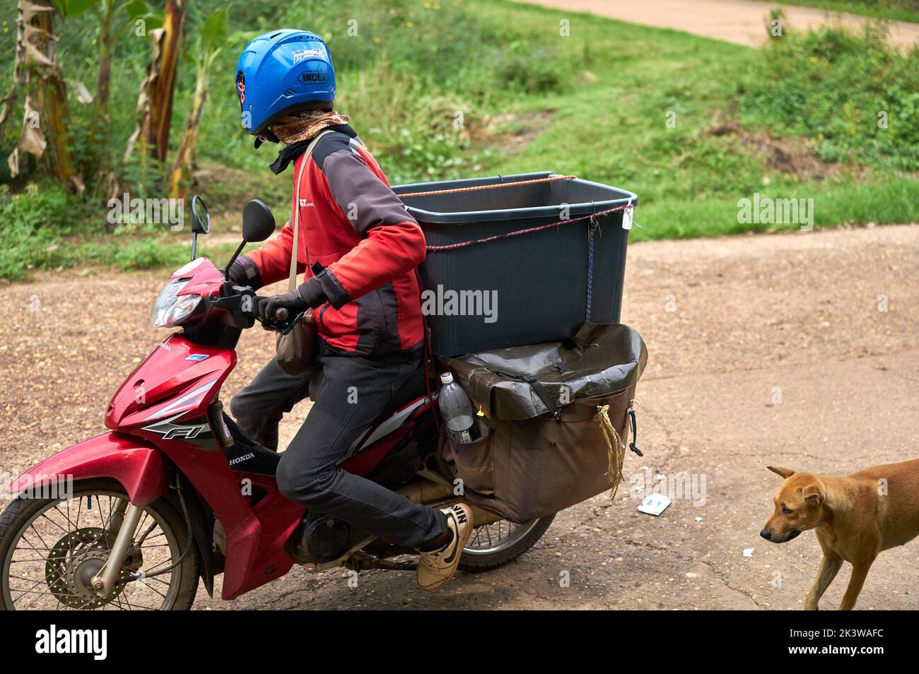 A motorcycle courier delivers packages in a rural area Stock Photo Alamy