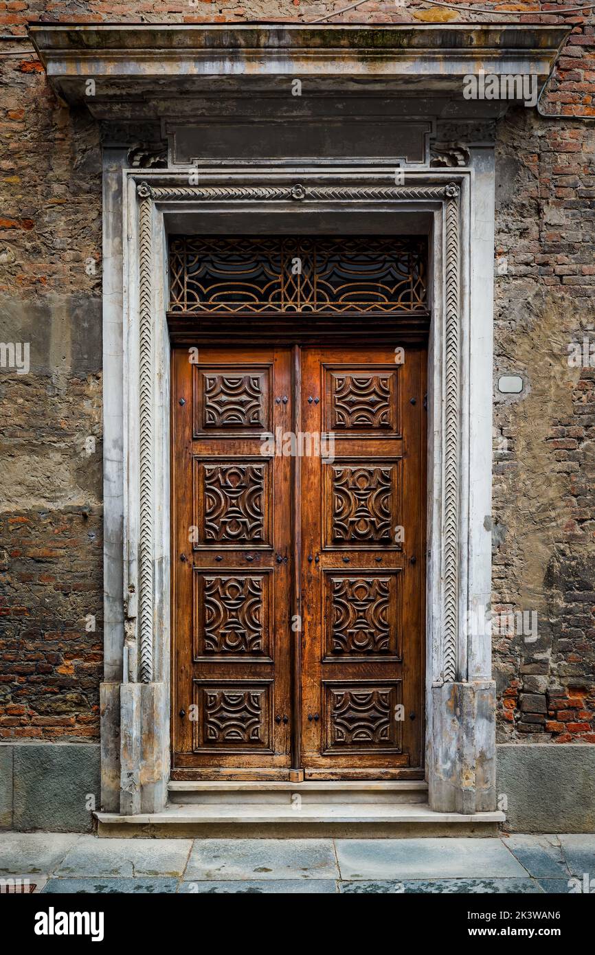 Vintage ornate wooden door in old town of Alba, Piedmont, Northern Italy. Stock Photo