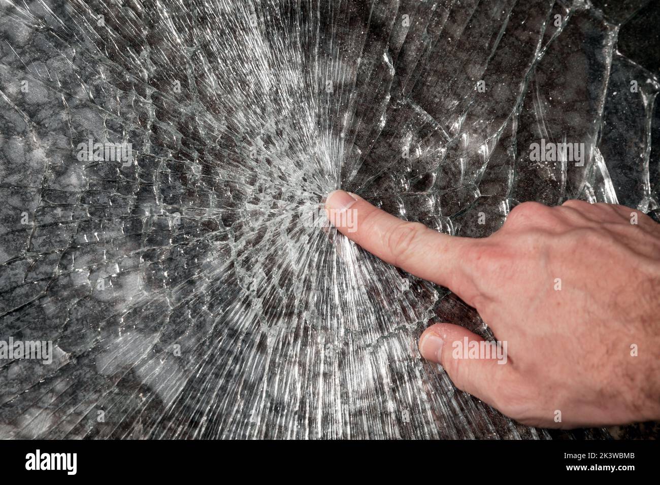 Male hand points broken window glass, close up photo Stock Photo