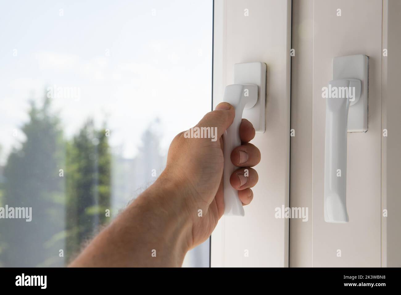Male hand opens modern plastic window, first person view Stock Photo