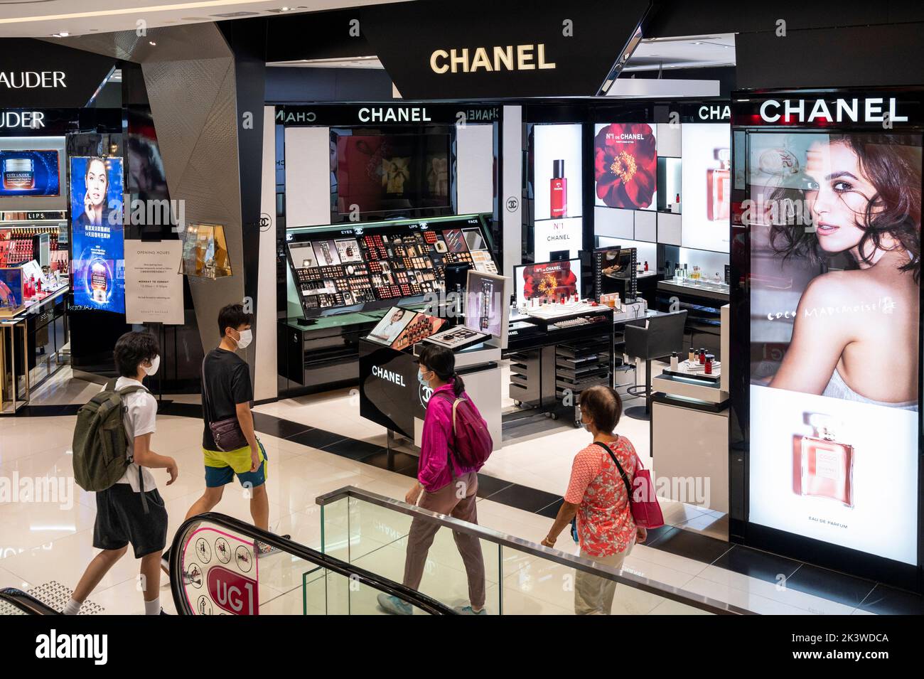 Shoppers walk past the French multinational Chanel clothing and beauty products brand store in Hong Kong. Stock Photo