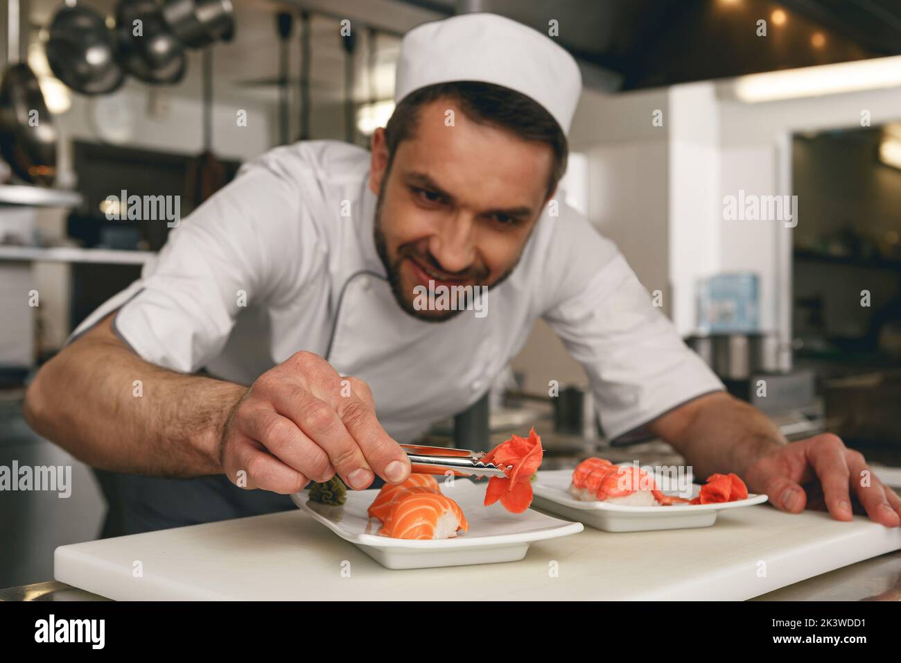 Sushi master prepares sushi for serving in modern commercial kitchen Stock Photo