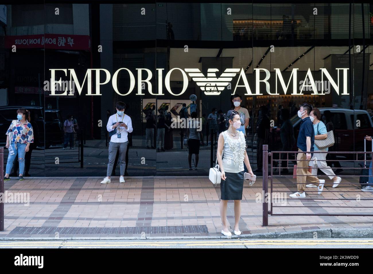 Pedestrians are seen outside the Italian fashion brand Emporio Armani store in Hong Kong. Stock Photo