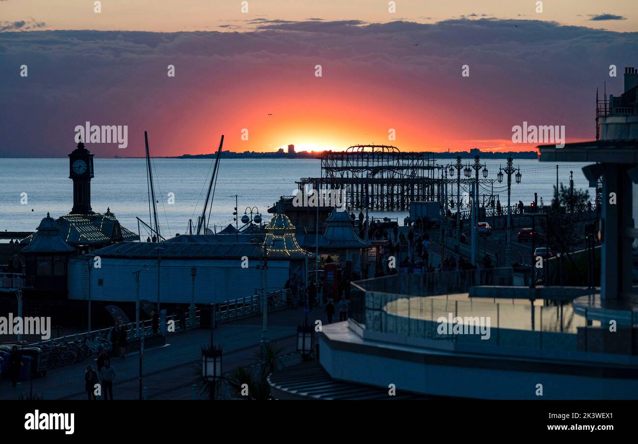 Brighton UK 28th September 2022 - The sun sets behind the West Pier on Brighton seafront after a beautiful Autumnal day along the South Coast . However wet and windy weather is forecast to arrive on Friday in the UK . : Credit Simon Dack / Alamy Live News Stock Photo