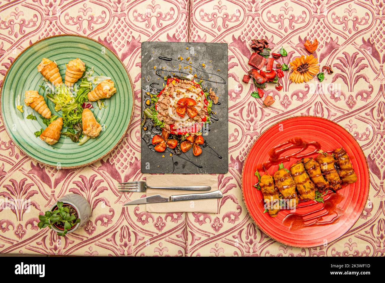 Several plates of food with croquettes, cones with salad and Russian salad with tomato and canned tuna Stock Photo