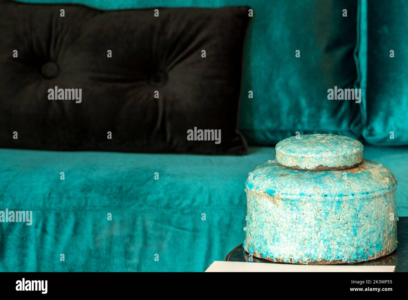 Detail of a living room with a decorative blue bowl and matching velvet sofa Stock Photo