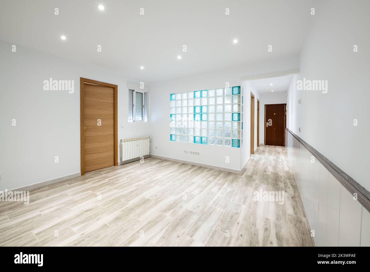 Empty room with glass pave skylight on one wall and gray tone wood simil stoneware flooring Stock Photo