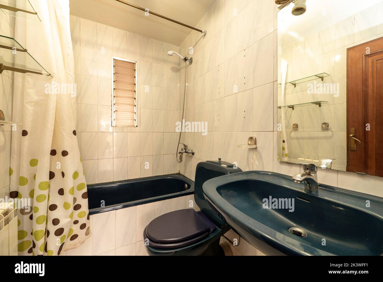 Blue porcelain pedestal sink with matching frameless mirror in small