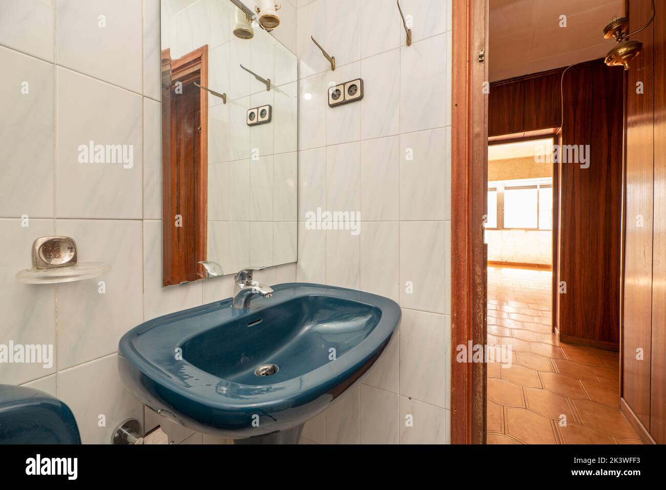 Blue porcelain pedestal sink with matching frameless mirror in small
