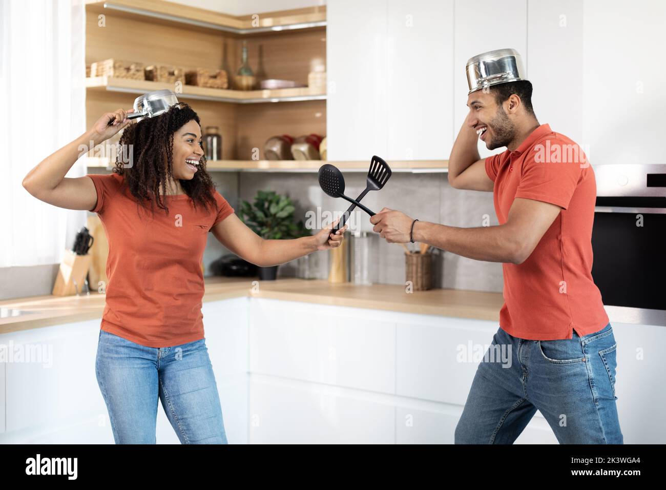 Happy millennial african american woman and man have fun, fighting with imaginary swords Stock Photo