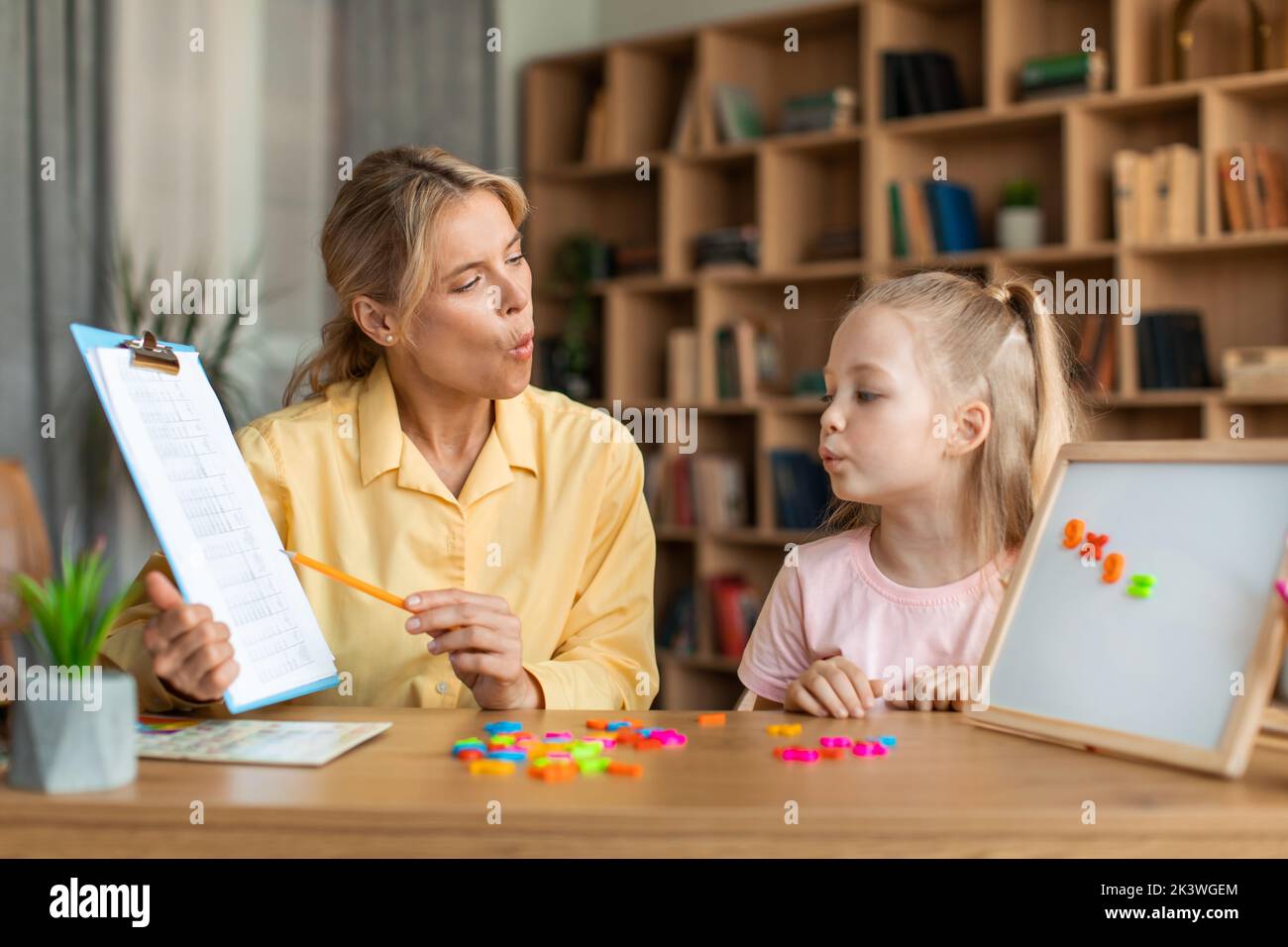 Speech training for kids. Female specialist training with smart little