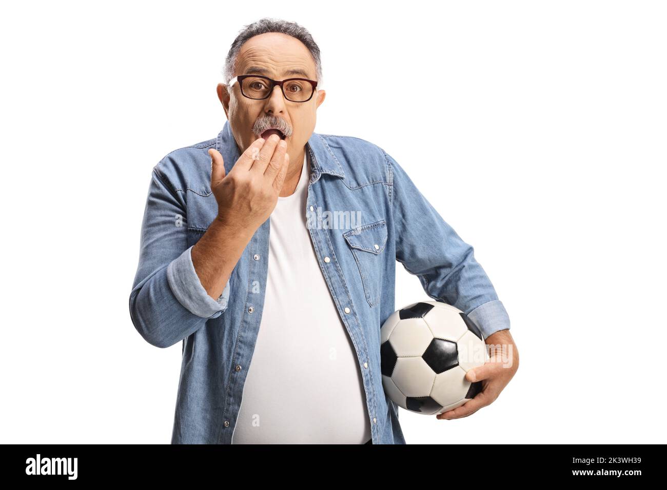 Shocked mature man holding a football and covering his mouth isolated on white background Stock Photo