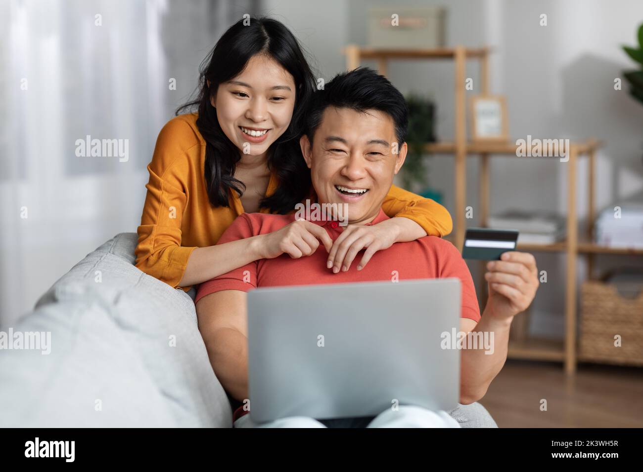 Happy asian spouses using notebook and credit card Stock Photo