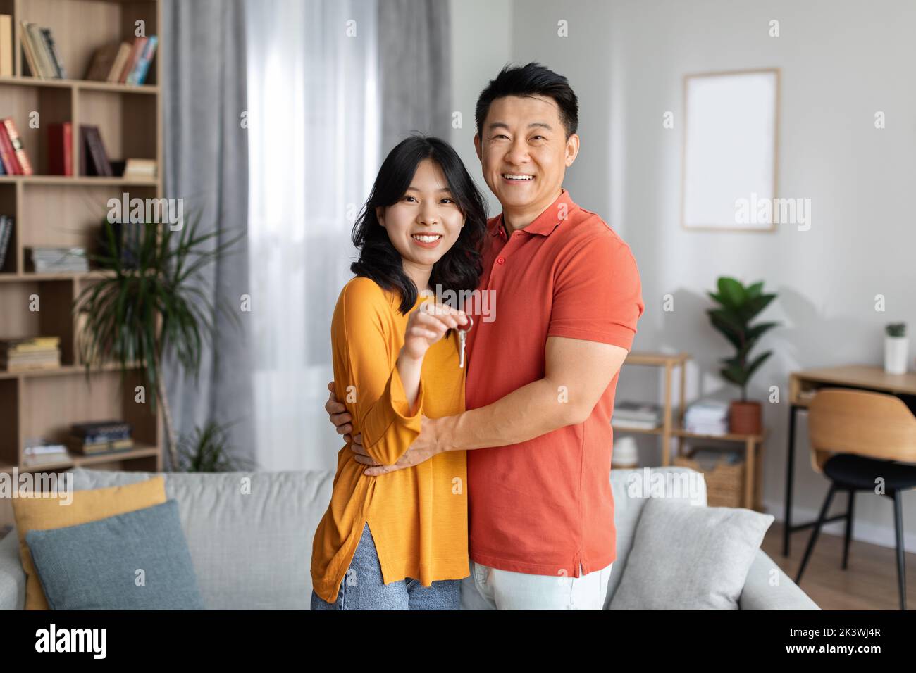 Happy asian couple showing key from their new apartment Stock Photo - Alamy