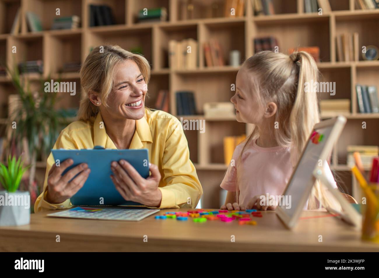 Preschool education concept. Clever girl learning alphabet, exercising