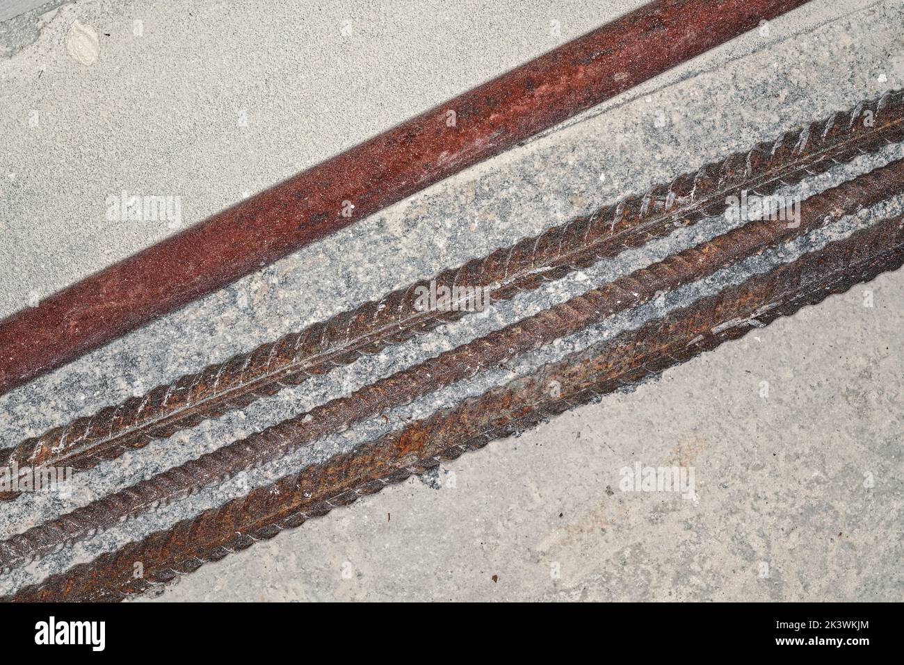 Iron rusty construction rebars on concrete ground at building site closeup detail from above Stock Photo