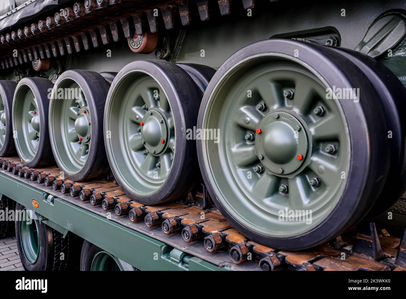 Tank armoured vehicle loaded at truck, detail to wheels on continuous tread tracks Stock Photo