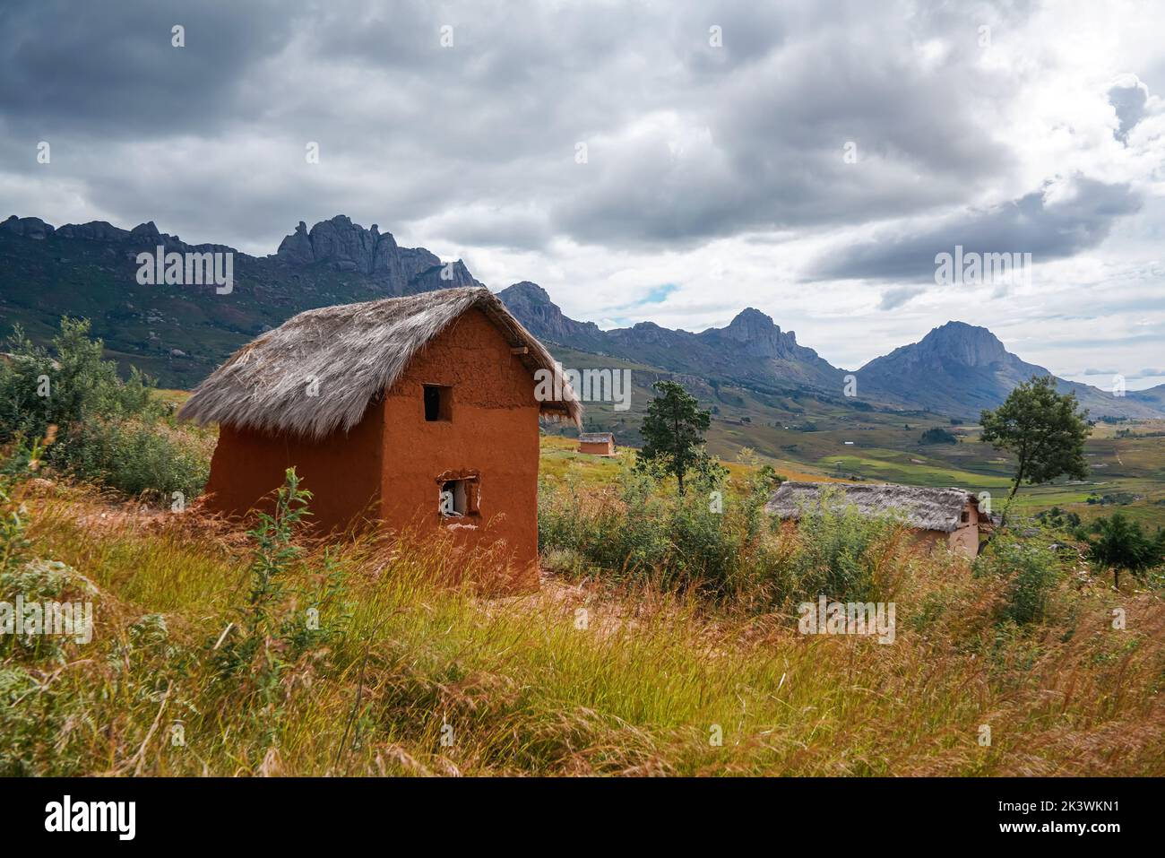 Typical landscape at Andringitra National Park, Madagascar on overcast day. Rocky mountains with rice fields under at distance, small clay house with Stock Photo