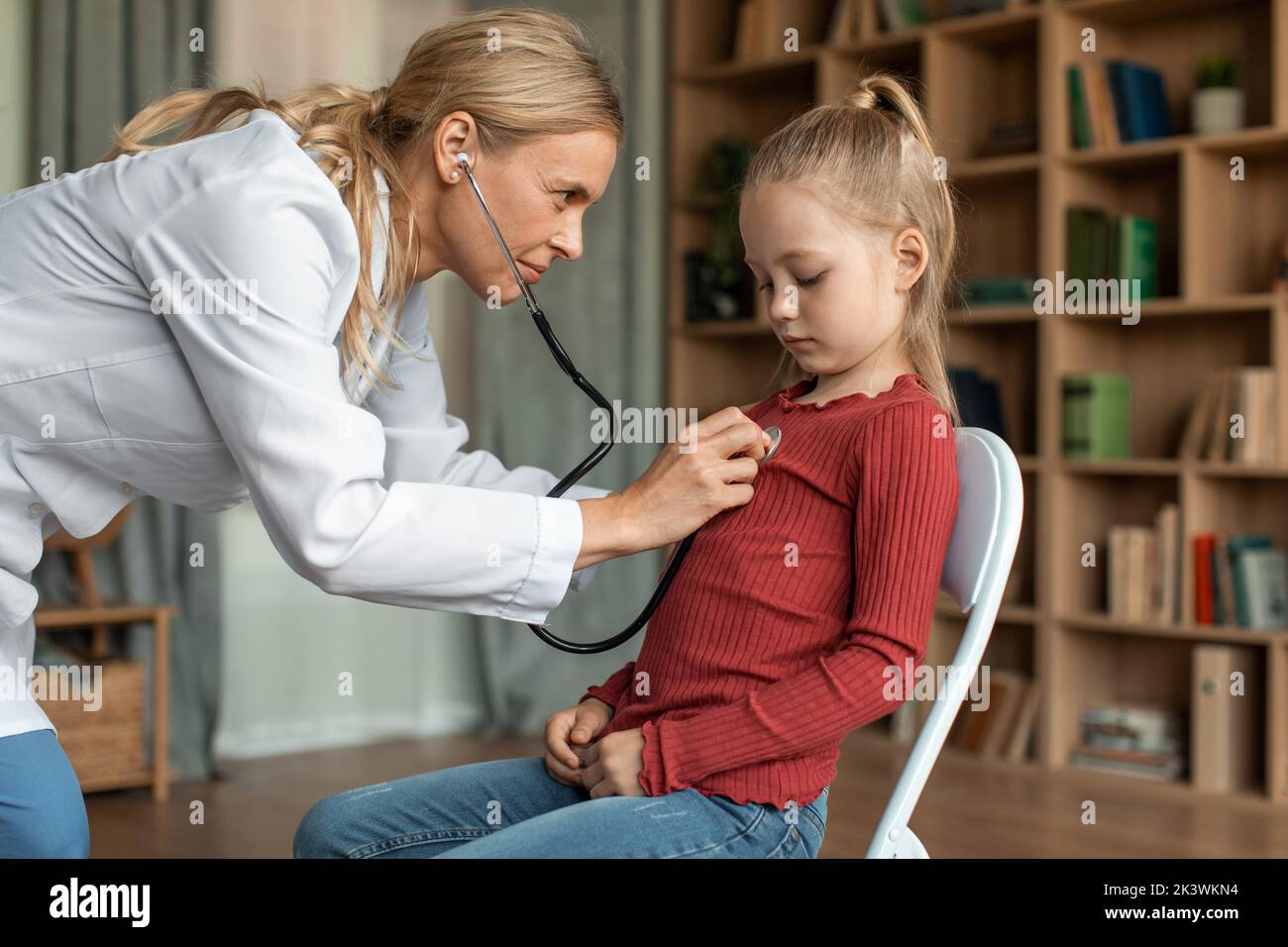 Doctor examining back of 8 year-old girl - Stock Image - C040/1358 -  Science Photo Library